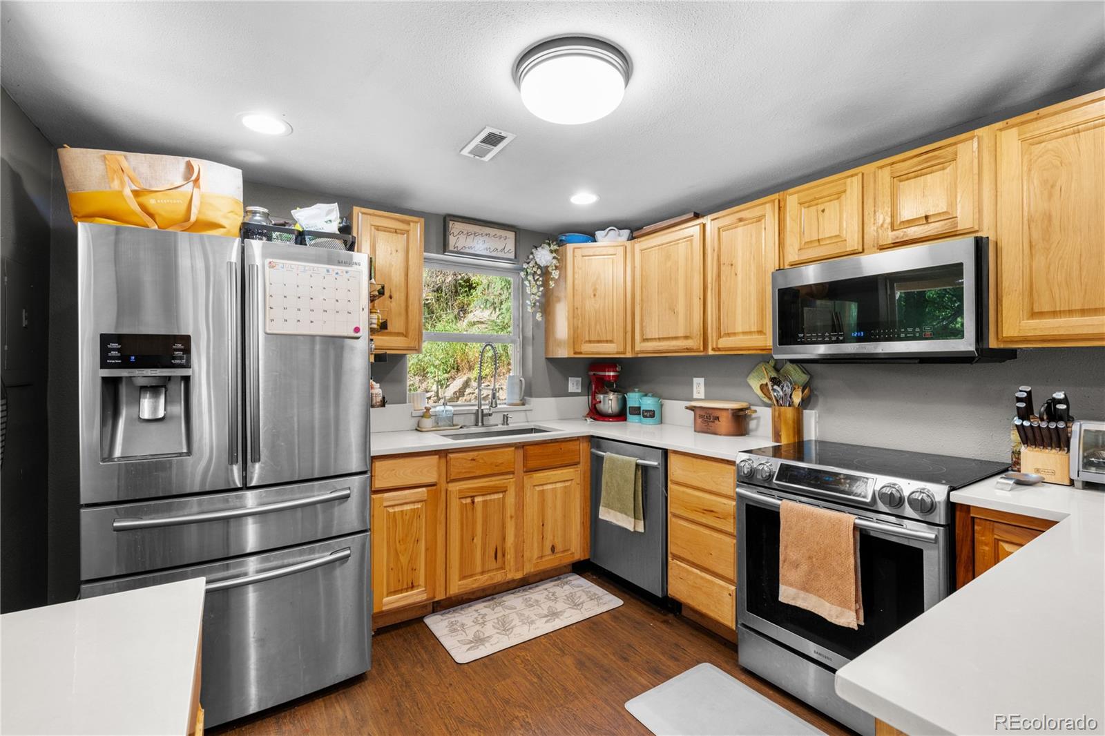 5211 Parmalee Gulch Road Indian Hills, CO 80454 - Photo 7 of 43 a kitchen with stainless steel appliances granite countertop a refrigerator a sink dishwasher a stove and a microwave