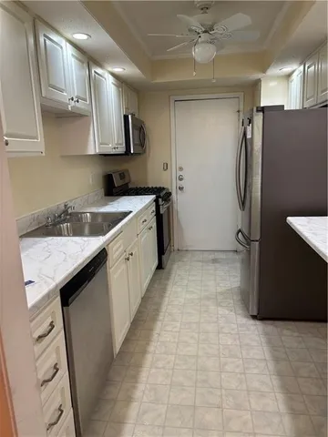 a kitchen with granite countertop a sink and a stove top oven