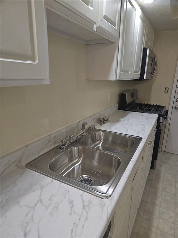 6851 Roswell Road, Unit I15 Atlanta, GA 30328 - Photo 18 of 29 a kitchen with granite countertop a sink and a stove top oven