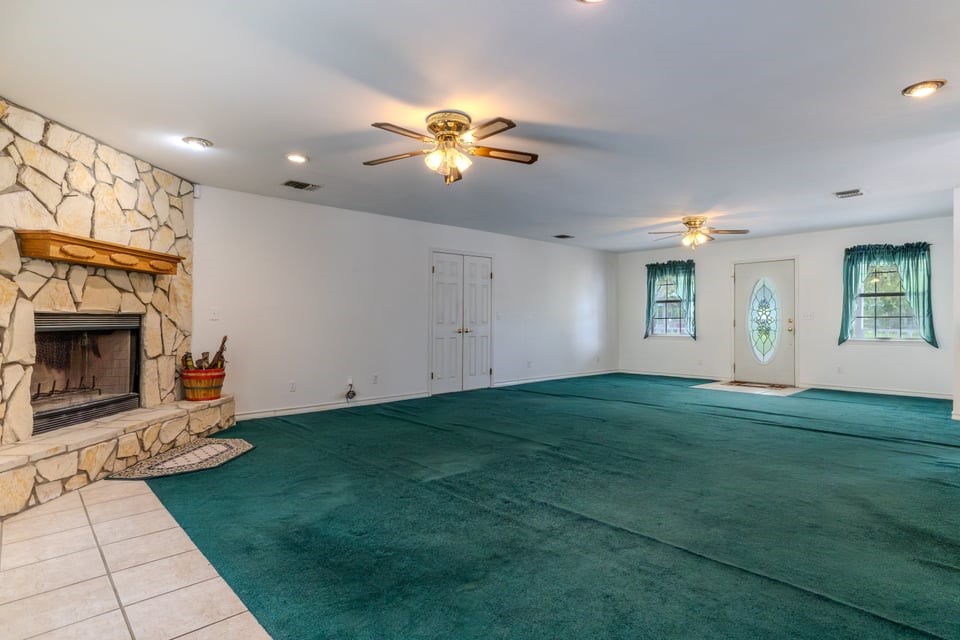 483 Riverside Drive Palacios, TX 77465 - Photo 13 of 41 a view of a livingroom with a fireplace a chandelier and windows