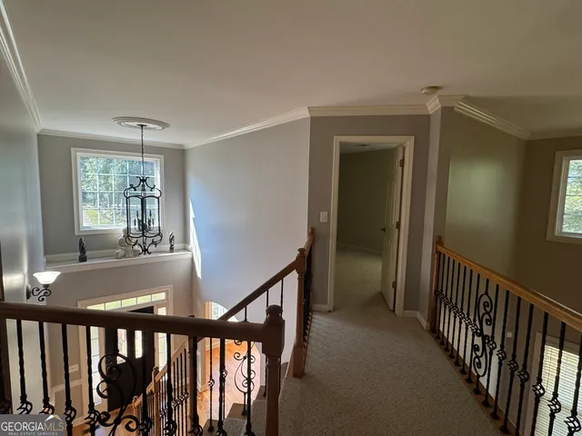 a view of a hallway with wooden floor and windows