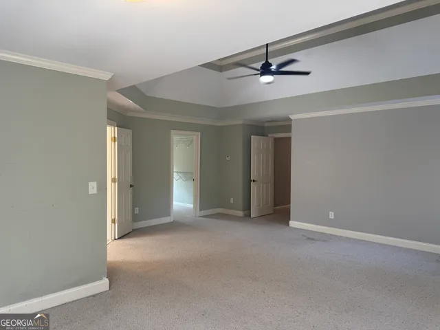 an empty room with closet and a ceiling fan
