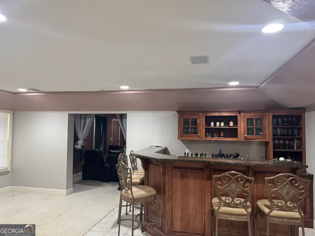 a living room with stainless steel appliances kitchen island granite countertop furniture and a refrigerator