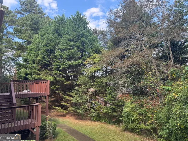 a view of a yard with plants and trees