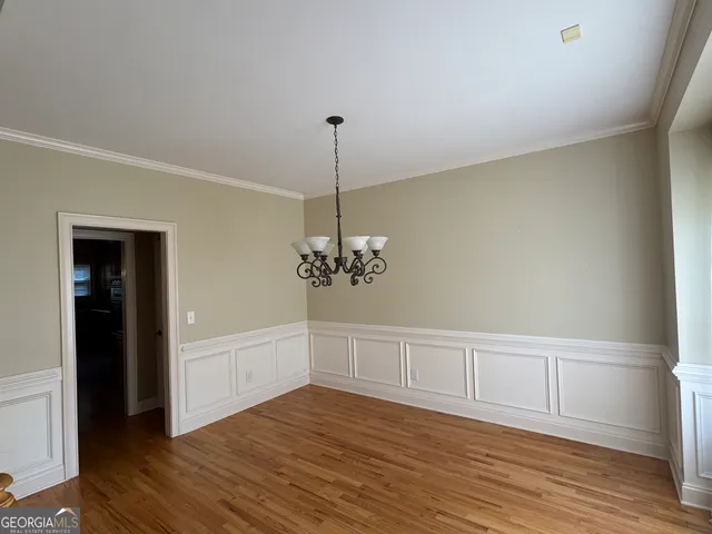 a view of a room with wooden floor chandelier and entryway