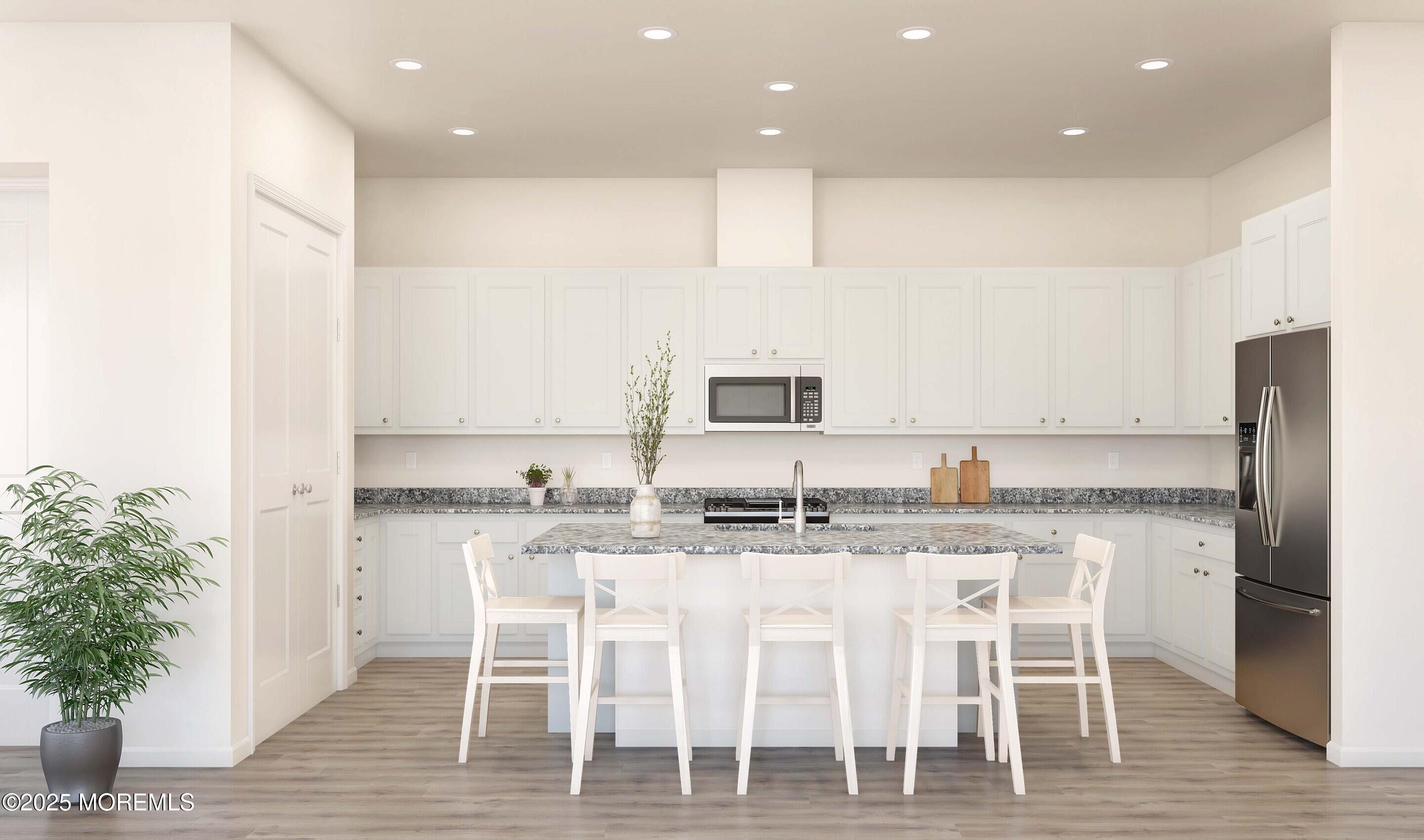 176 Highway 33, Unit PALMERA Manalapan, NJ 07726 - Photo 25 of 45 a kitchen with kitchen island granite countertop a sink and refrigerator
