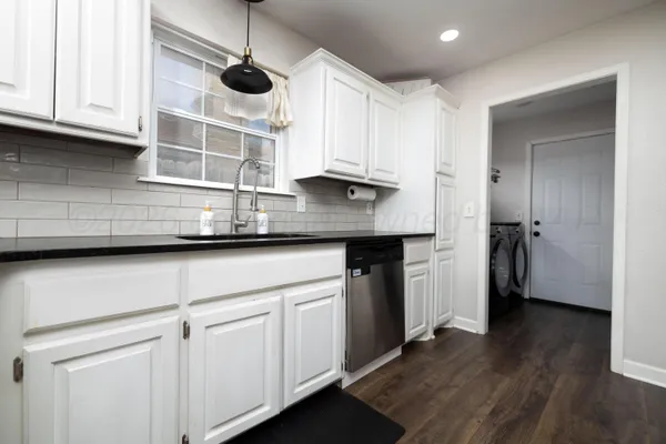 a kitchen with stainless steel appliances granite countertop a sink a stove a refrigerator and cabinets