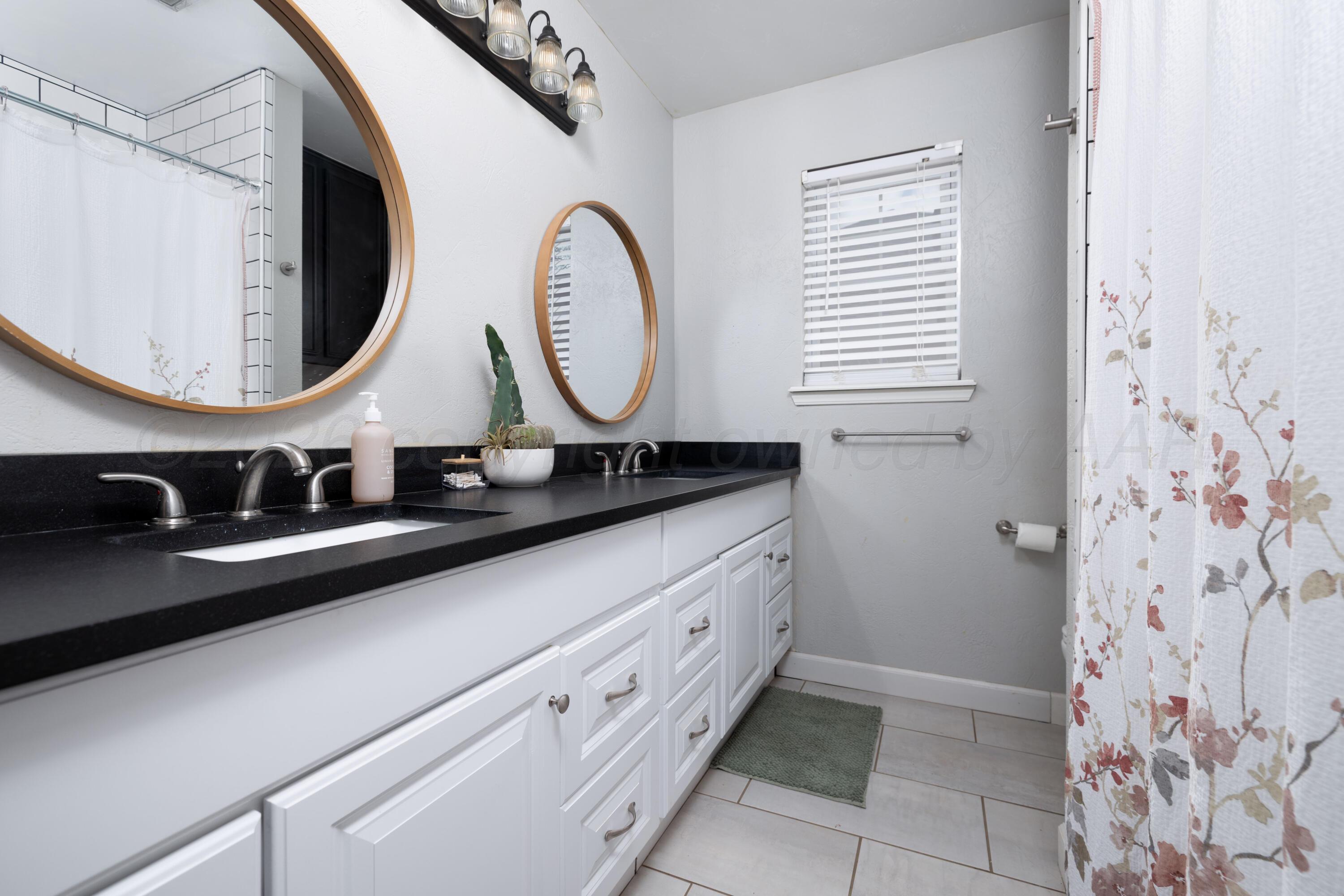 3509 Timber Drive Amarillo, TX 79121 - Photo 22 of 35 a bathroom with a sink a mirror and a window