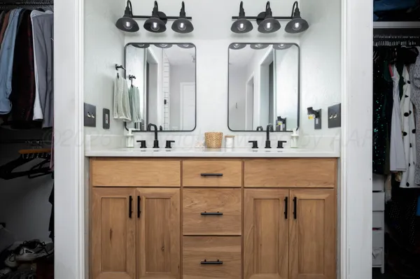 a bathroom with double vanity sinks a vanity and a mirror
