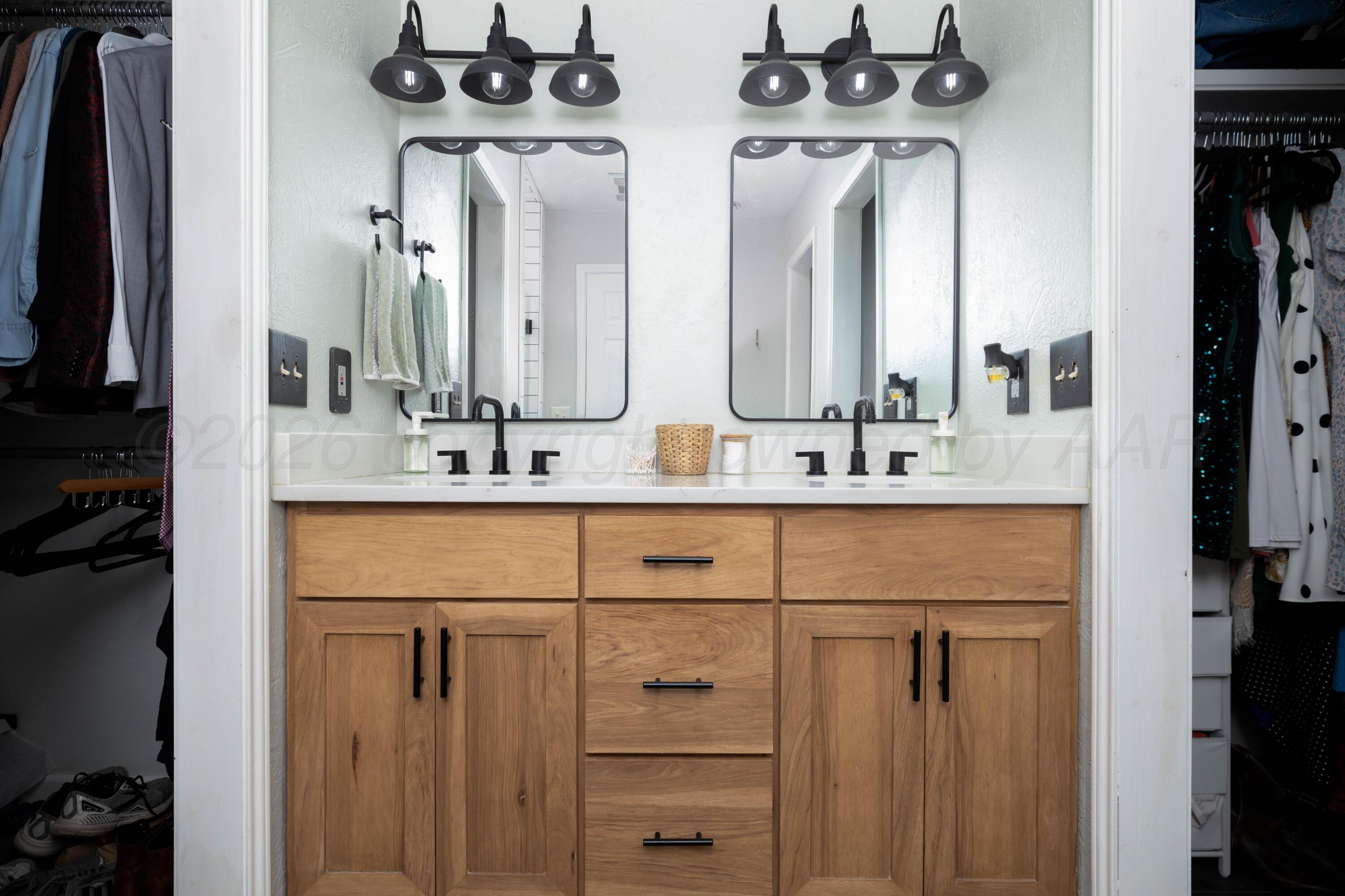 3509 Timber Drive Amarillo, TX 79121 - Photo 27 of 35 a bathroom with double vanity sinks a vanity and a mirror