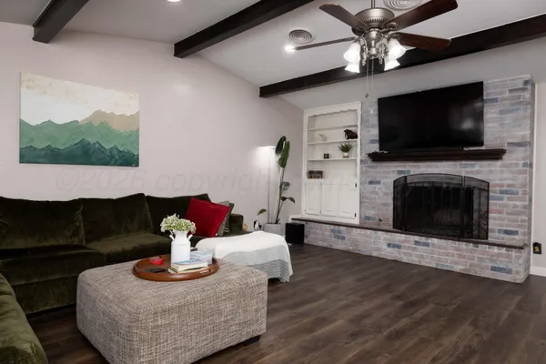 a living room with furniture a flat screen tv and a fireplace