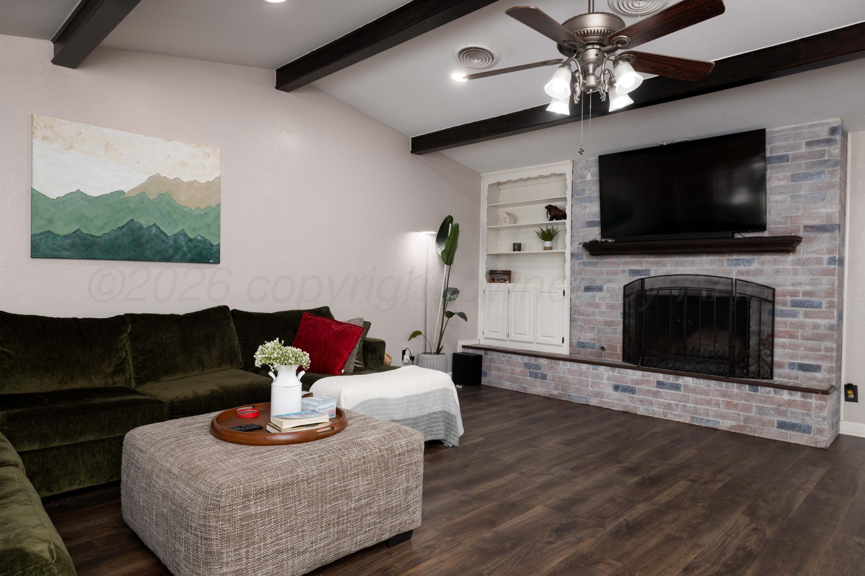 3509 Timber Drive Amarillo, TX 79121 - Photo 4 of 35 a living room with furniture a flat screen tv and a fireplace