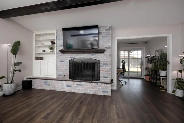 a living room with furniture a flat screen tv and a fireplace