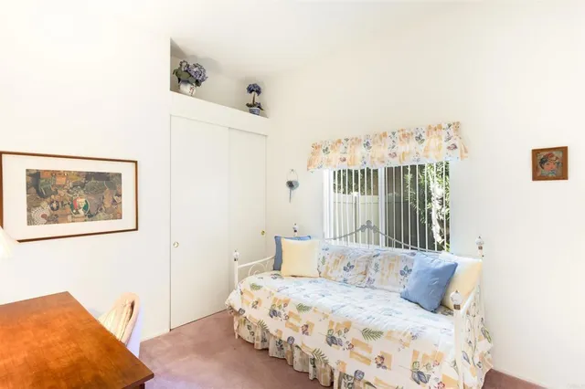 a bedroom with a bed and a painting on the wall