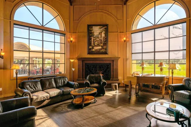 a living room with furniture a fireplace and large windows