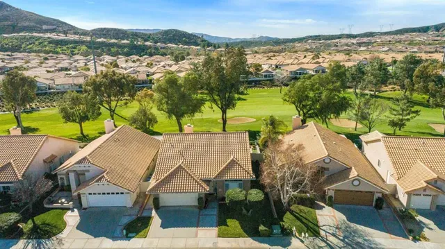 an aerial view of residential houses with outdoor space and ocean view