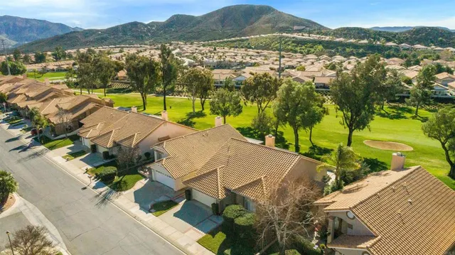 an aerial view of a house with yard and mountain view in back