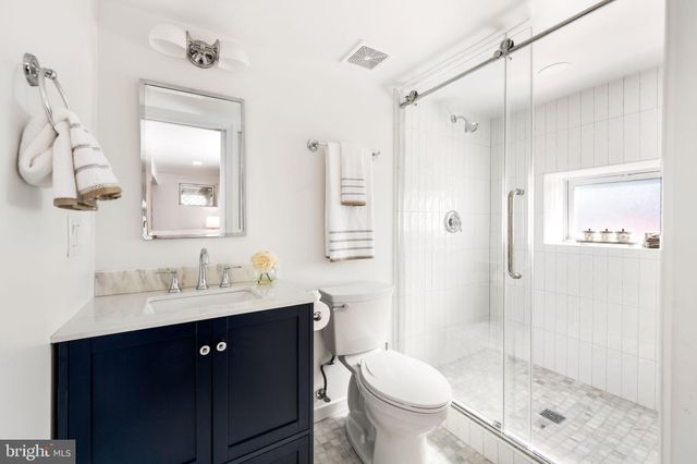 a bathroom with a sink vanity granite toilet and shower