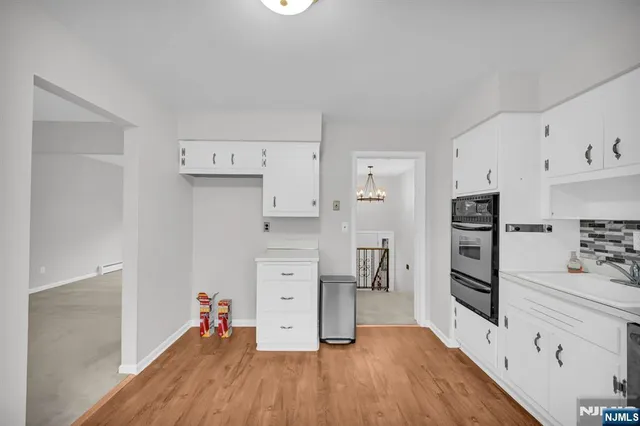 a kitchen with white cabinets and stainless steel appliances
