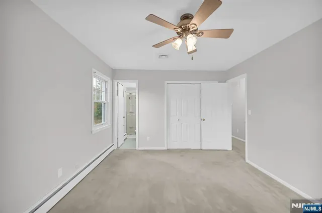 an empty room with a ceiling fan and a window