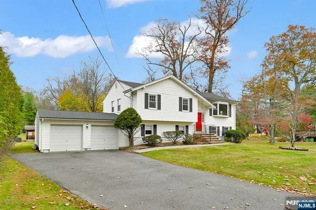 a view of a white house with a yard and palm trees