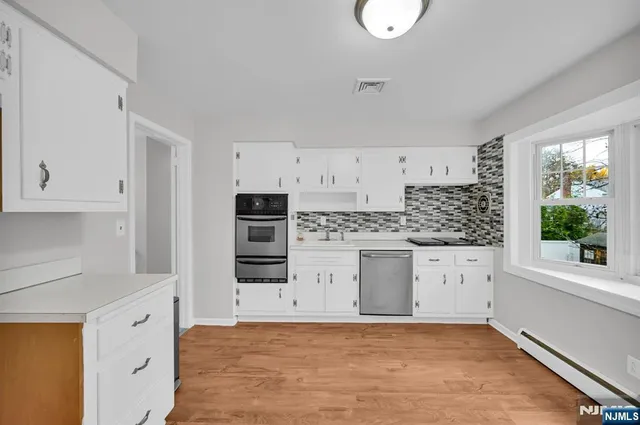 a kitchen with granite countertop a stove a sink and a refrigerator