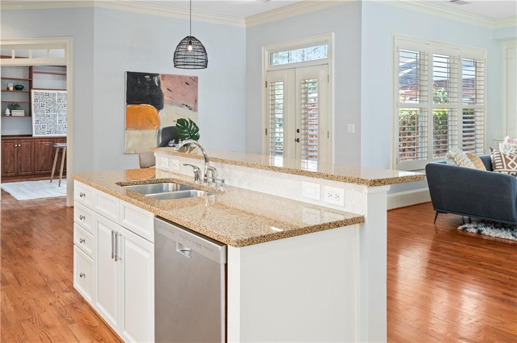 932 Manor Parc Drive Decatur, GA 30033 - Photo 10 of 38 a hallway with kitchen island granite countertop a sink a stove and a wooden floor