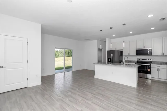 a kitchen with stainless steel appliances granite countertop a refrigerator stove microwave and sink