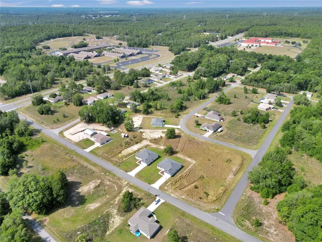 an aerial view of a residential houses with outdoor space and river