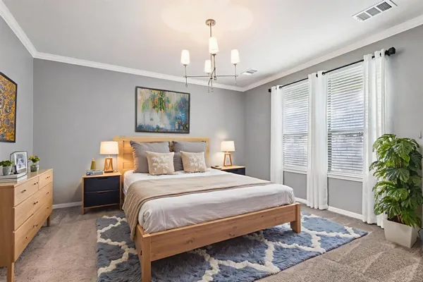 a bedroom with bed a chandelier and a window