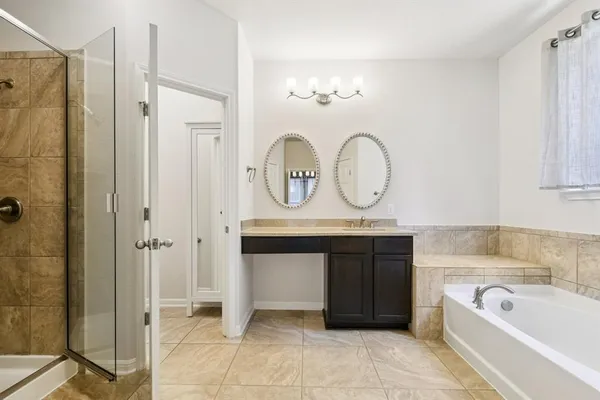 a bathroom with a tub a sink and a mirror