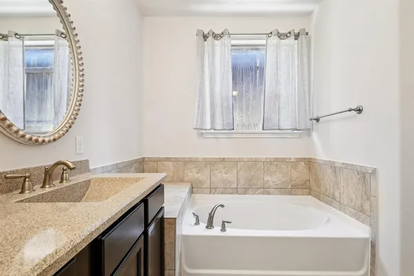 a bathroom with a granite countertop sink and a mirror