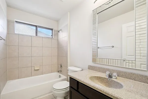 a bathroom with a granite countertop sink a toilet and shower