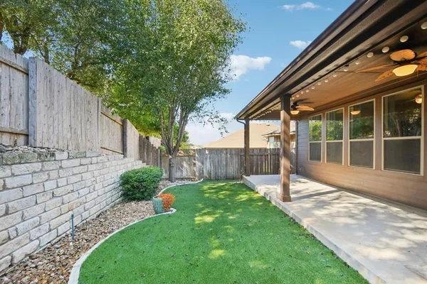 a view of a backyard with a small cabin and wooden fence