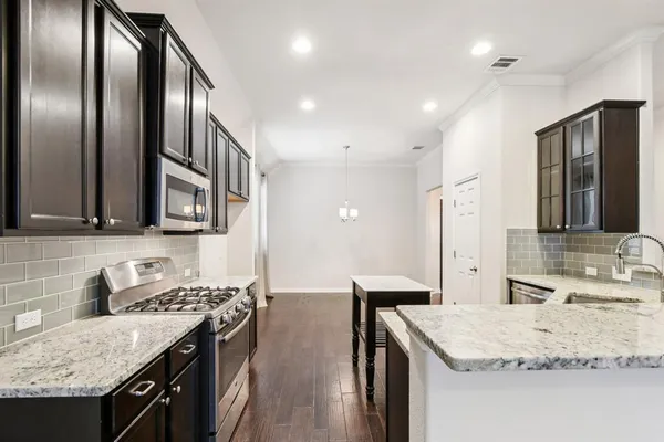 a kitchen with stainless steel appliances granite countertop a sink stove and refrigerator