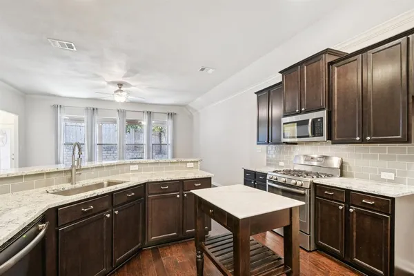 a kitchen with stainless steel appliances granite countertop a sink stove and refrigerator
