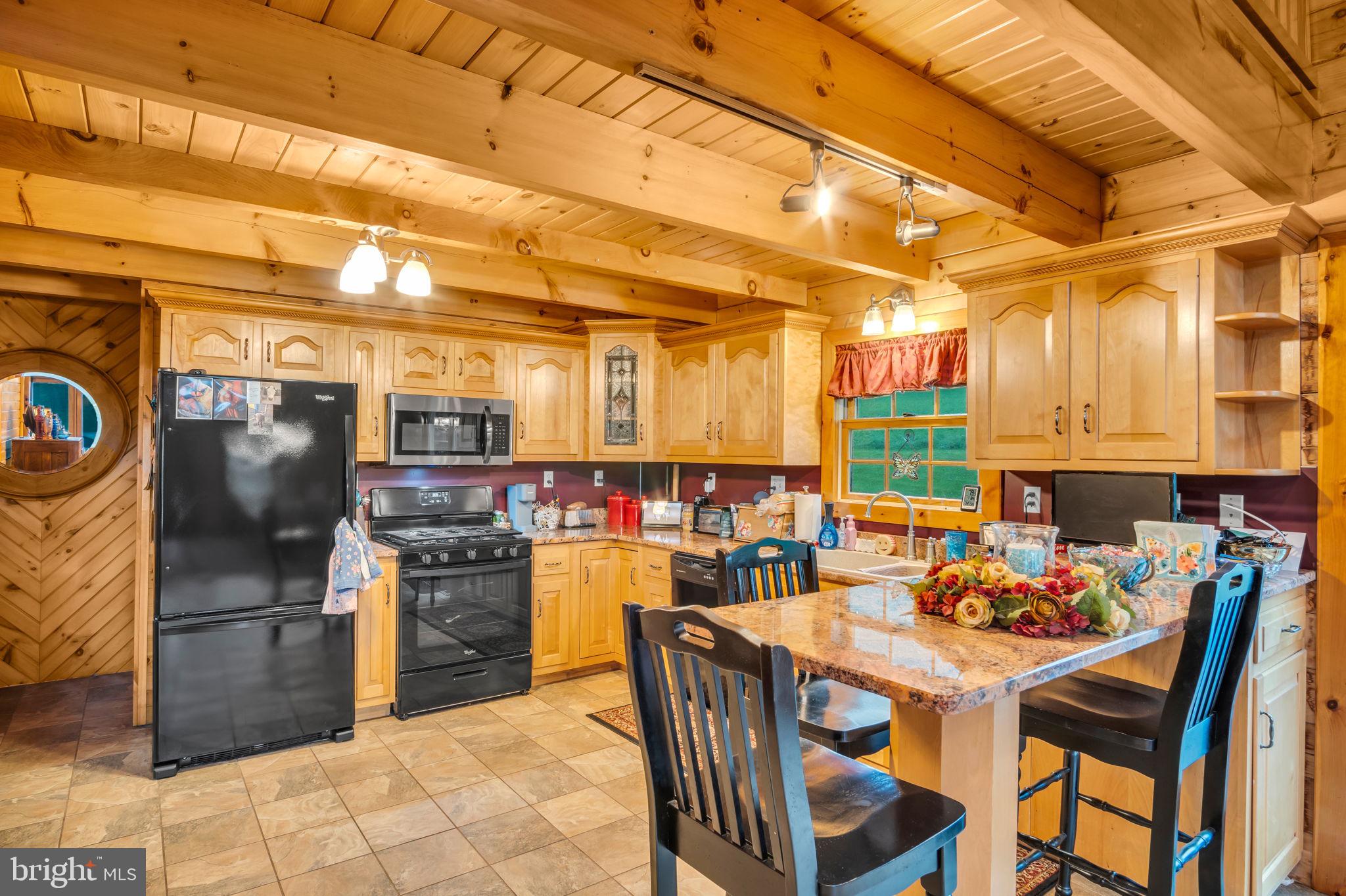 1105 Ridge Road Halifax, PA 17032 - Photo 27 of 61 a kitchen with stainless steel appliances kitchen island granite countertop a table chairs and a refrigerator