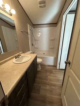a bathroom with a sink a toilet a mirror and shower