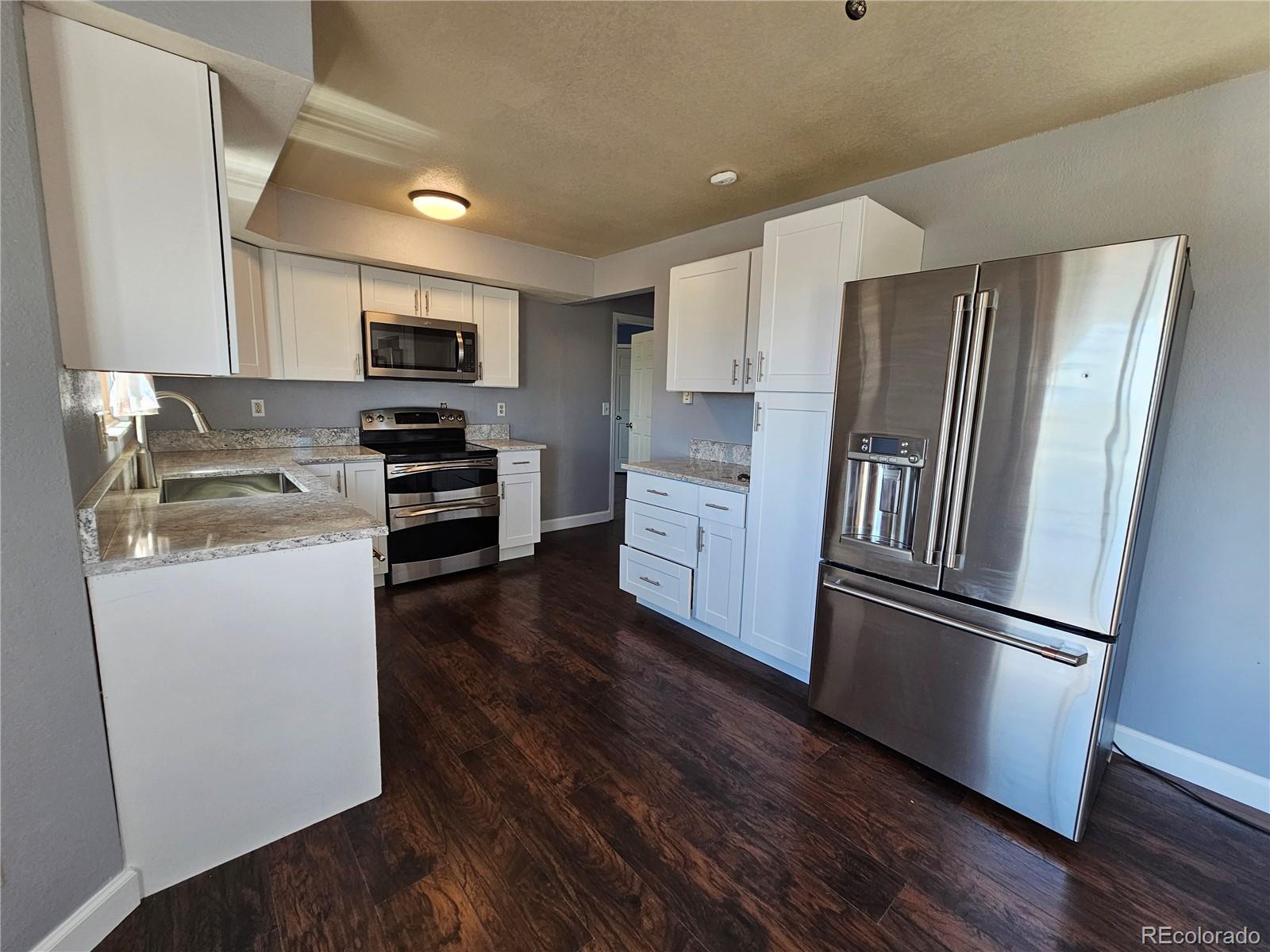 16985 Sage Crest Road Peyton, CO 80831 - Photo 8 of 25 a kitchen with stainless steel appliances a refrigerator sink and microwave