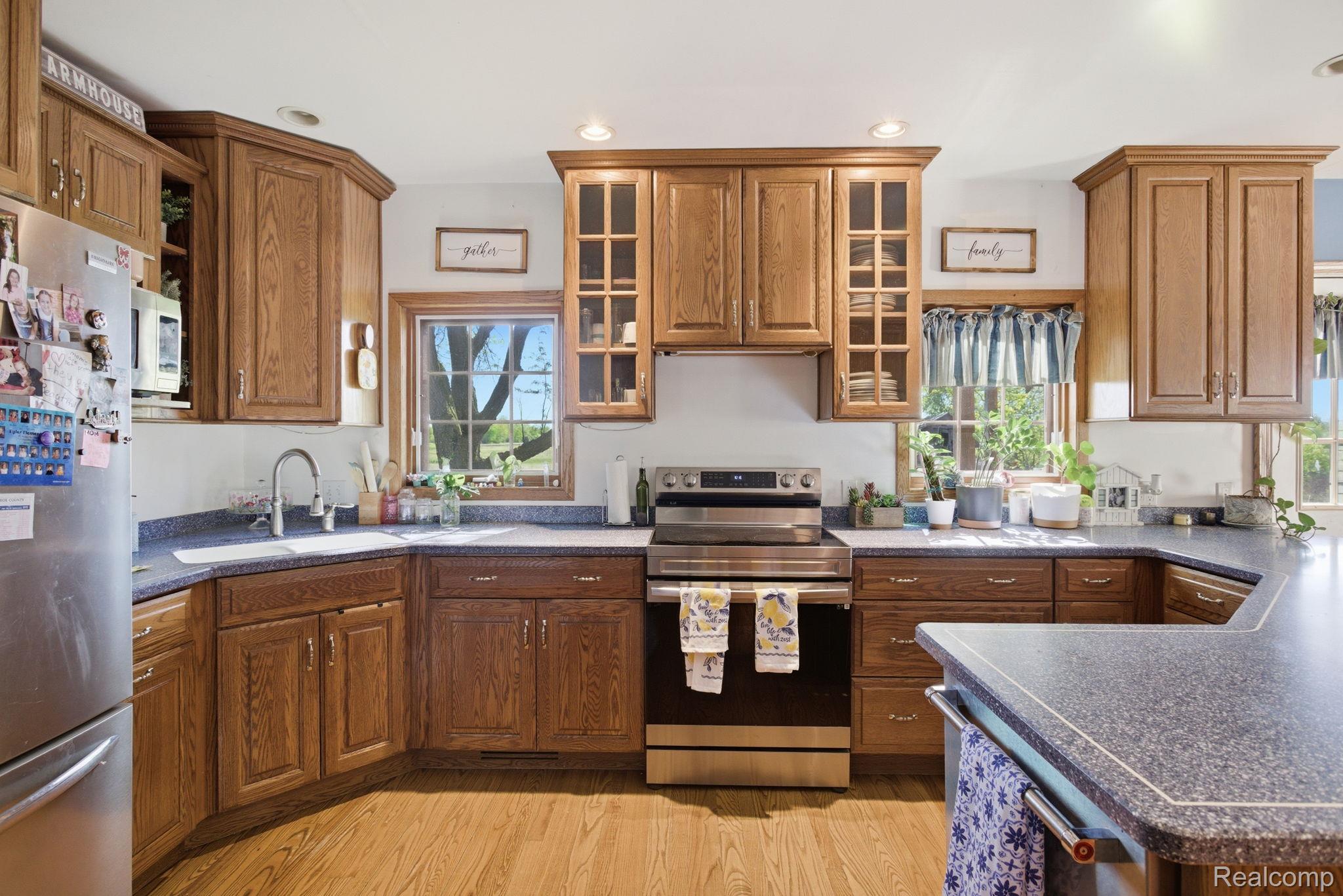 14104 Carleton West Road Carleton, MI 48117 - Photo 20 of 58 Kitchen featuring stainless steel appliances, glass insert cabinets, wood finish cabinets, light wood-style floors, and recessed lighting