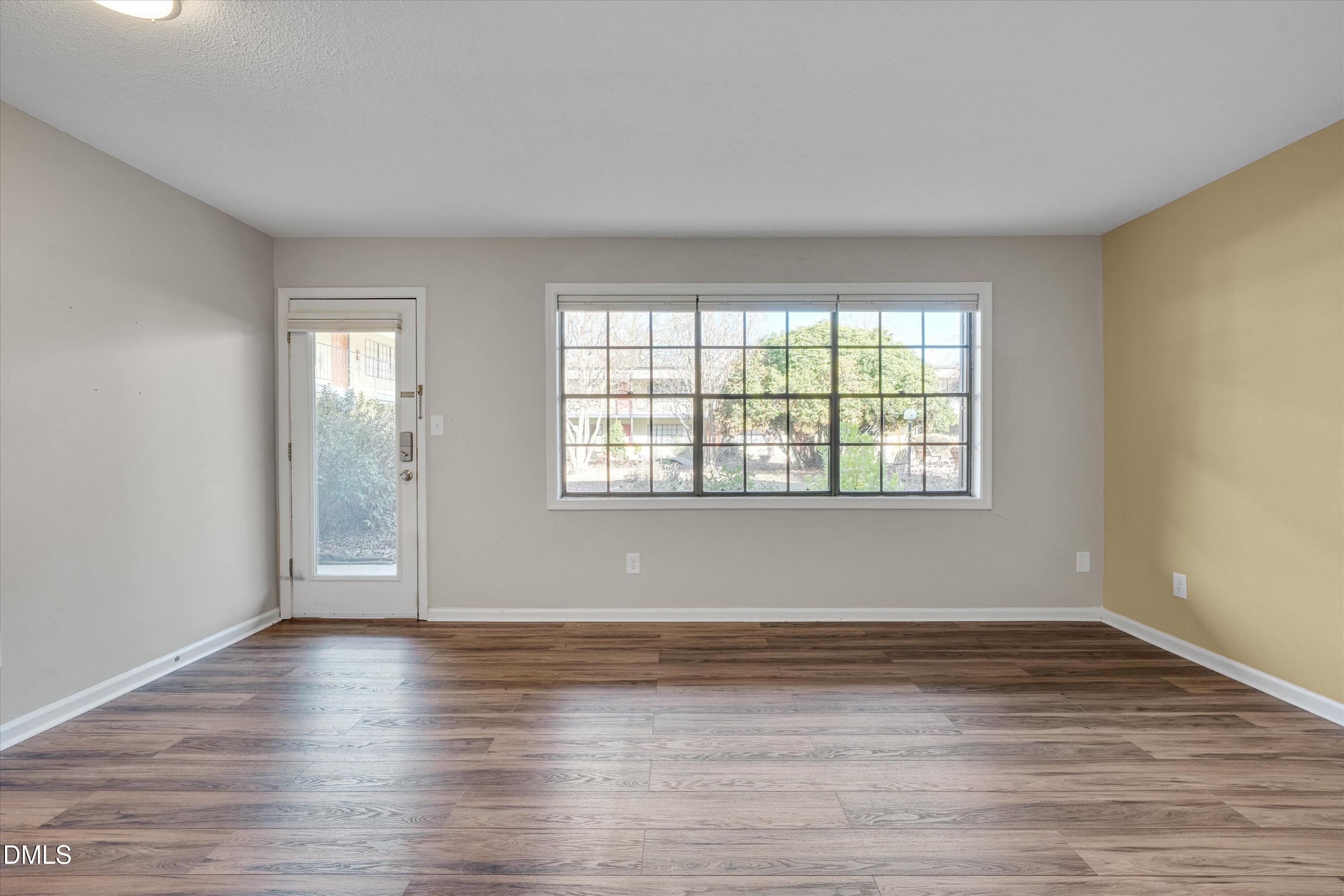 807 West Trinity Avenue, Unit 130 Durham, NC 27701 - Photo 10 of 44 an empty room with wooden floor and windows