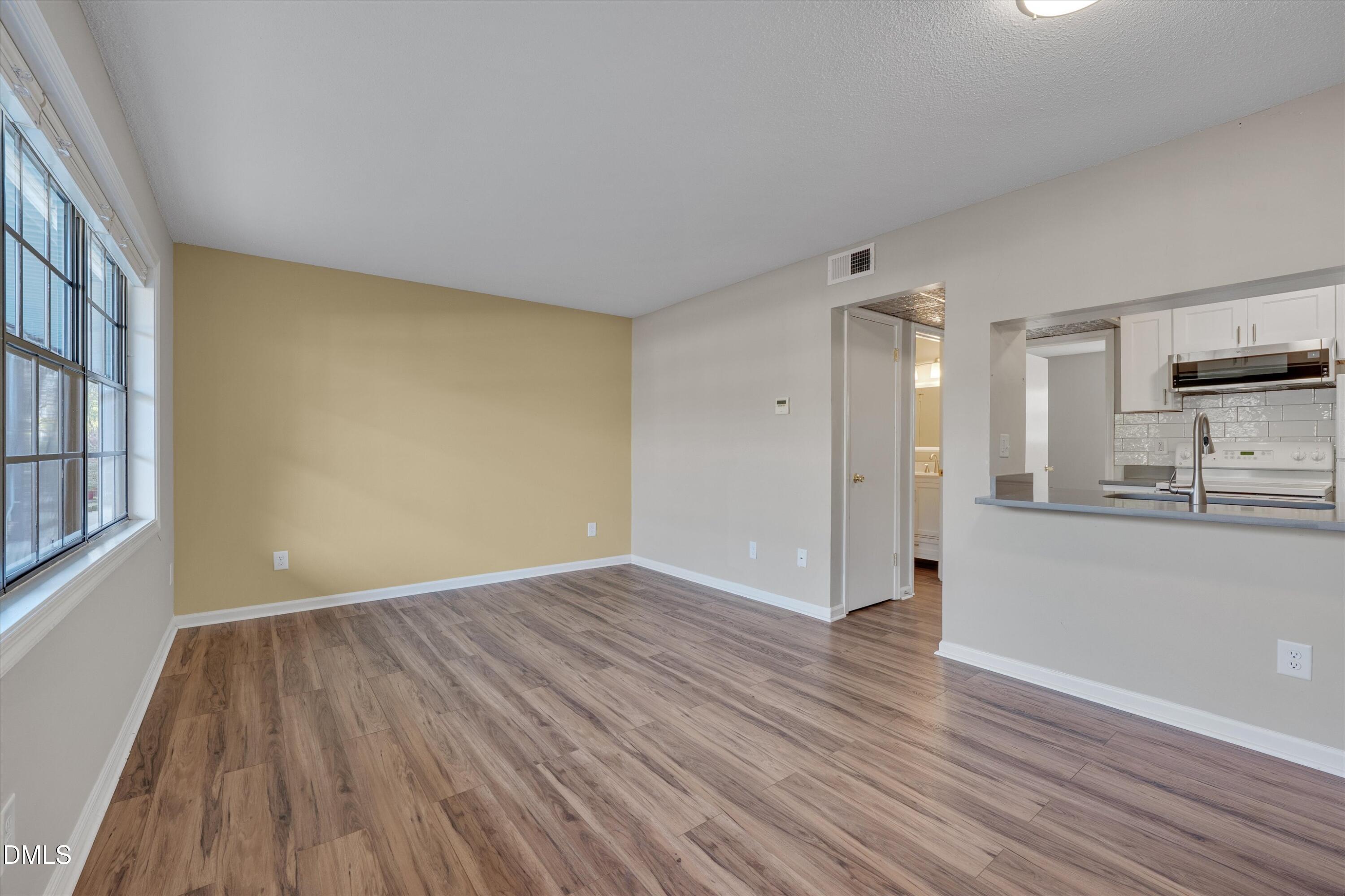 807 West Trinity Avenue, Unit 130 Durham, NC 27701 - Photo 12 of 44 a view of a kitchen with wooden floor and a sink