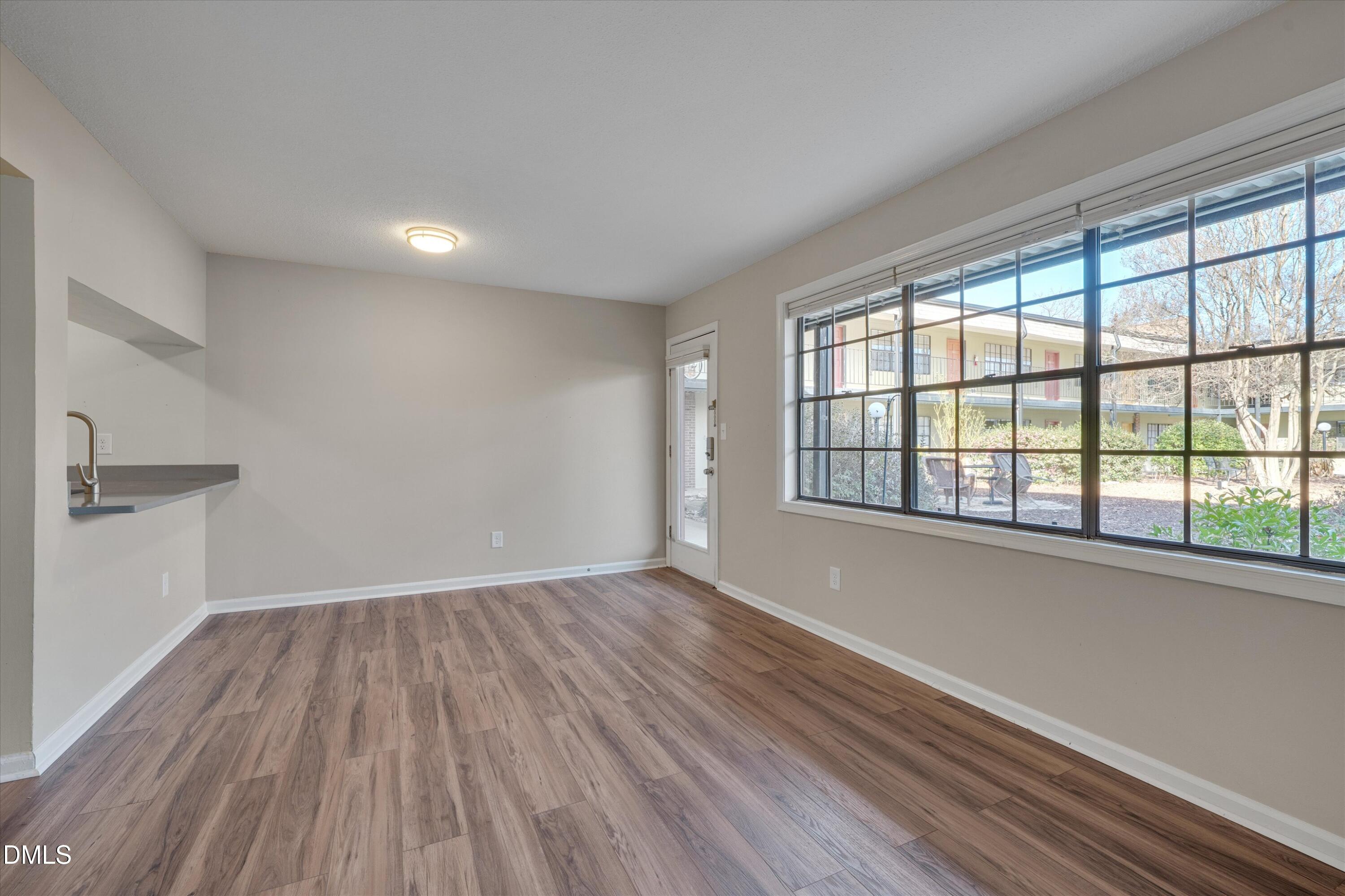 807 West Trinity Avenue, Unit 130 Durham, NC 27701 - Photo 13 of 44 wooden floor in an empty room with a window