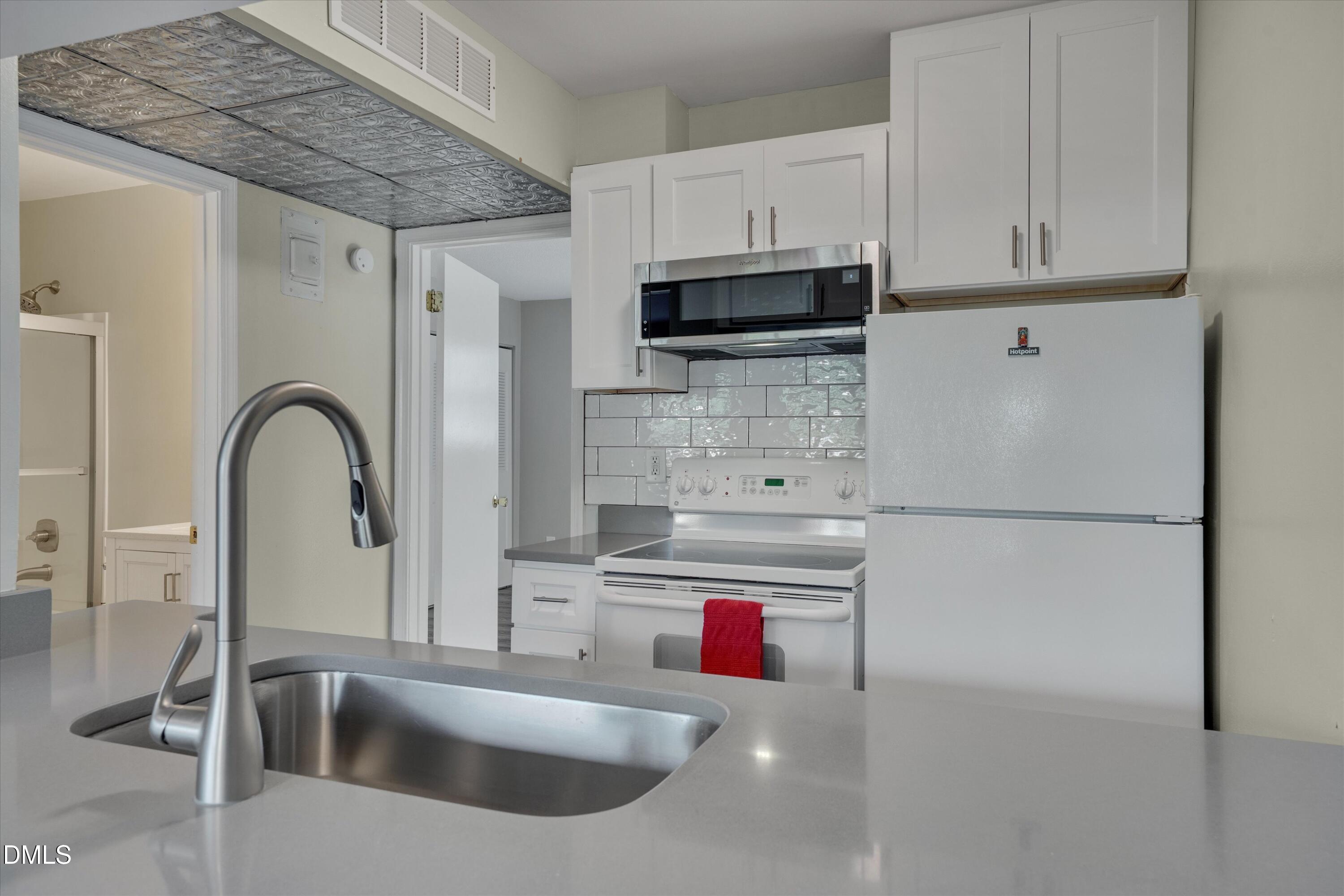 807 West Trinity Avenue, Unit 130 Durham, NC 27701 - Photo 16 of 44 a kitchen with stainless steel appliances a sink a stove and cabinets
