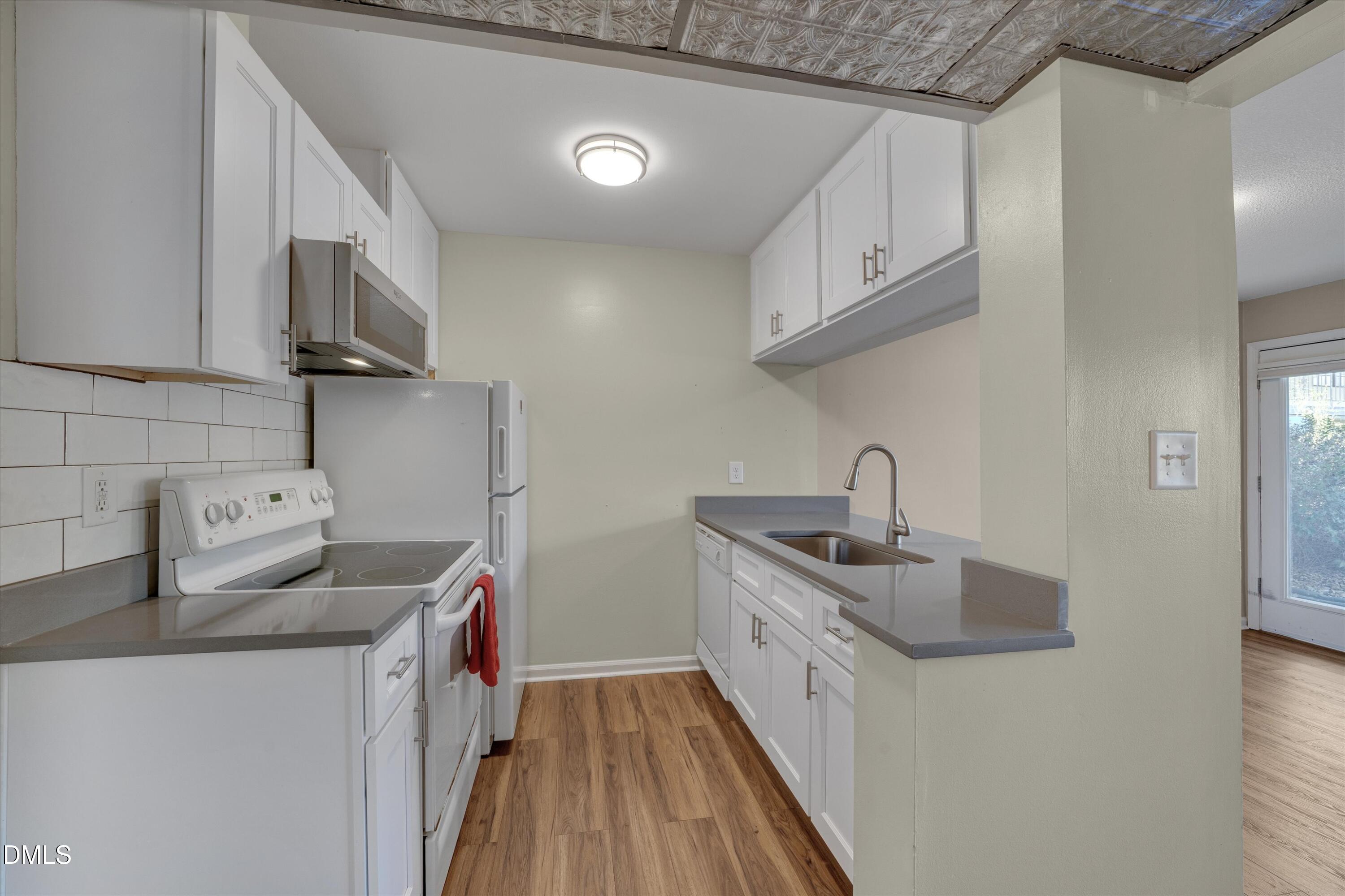 807 West Trinity Avenue, Unit 130 Durham, NC 27701 - Photo 18 of 44 a kitchen with stainless steel appliances granite countertop a sink stove and refrigerator