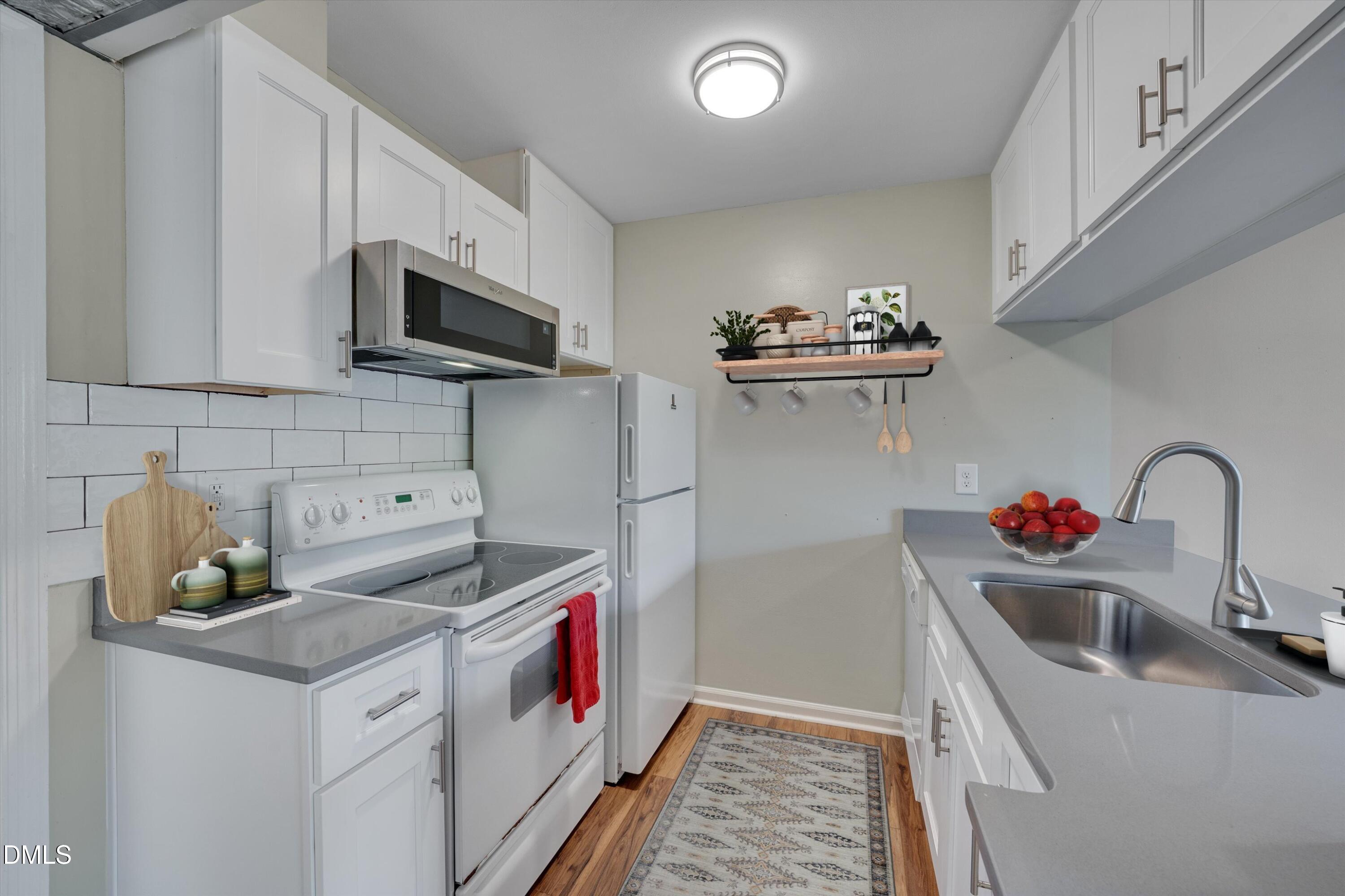 807 West Trinity Avenue, Unit 130 Durham, NC 27701 - Photo 2 of 44 a kitchen that has a sink and a stove