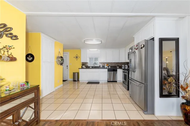 a kitchen with granite countertop a refrigerator and a stove top oven