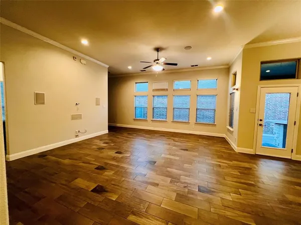 a view of an empty room with window and wooden floor
