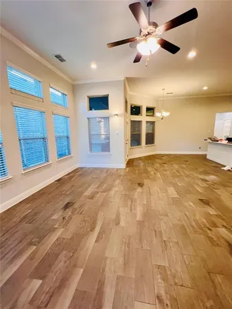 a view of an empty room with kitchen and a window