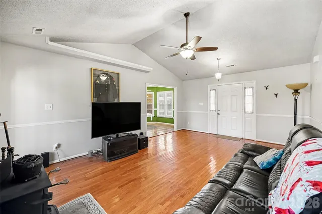 a spacious bedroom with a bed and a flat screen tv